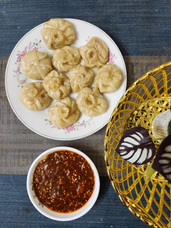 services-01 Plate of steaming dumplings served with spicy sauce for a delightful meal.